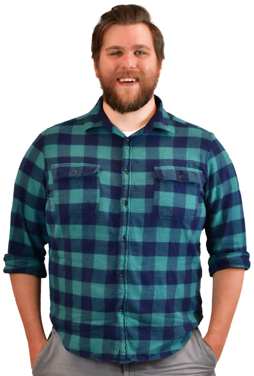 Front-end engineer, Dave Berning in a teal plaid flannel shirt and grey pants with his hands in his pockets, smiling and looking at the camera.